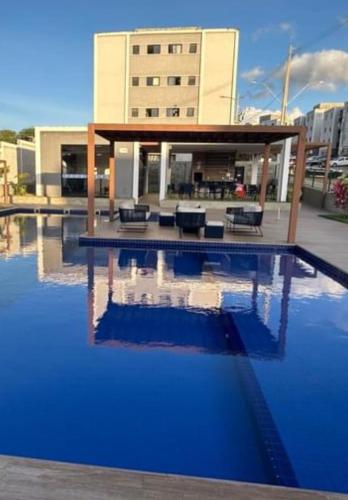 a swimming pool with blue water in front of a building at Apartamento Studio 003 in Caruaru