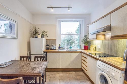 a kitchen with a table and a refrigerator at 1 Bed flat in East Dulwich in London