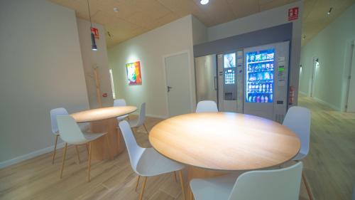 a conference room with two tables and white chairs at Hotel Sleep Turia music & art in Lliria