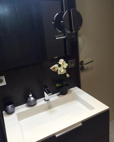 La salle de bains est pourvue d'un lavabo, d'un miroir et d'une plante. dans l'établissement Panoramic Cassis, à Cassis