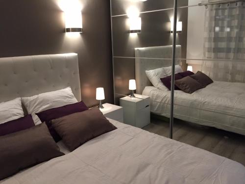 une chambre avec un lit blanc et un miroir dans l'établissement Panoramic Cassis, à Cassis