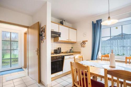 a kitchen and dining room with a table and chairs at Haus Clara in Neßmersiel