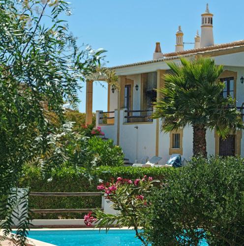 a villa with a swimming pool in front of a house at Belver Porto Dona Maria Resort in Luz