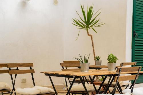 uma mesa de madeira com cadeiras e um vaso de plantas em La Puteca em Nápoles