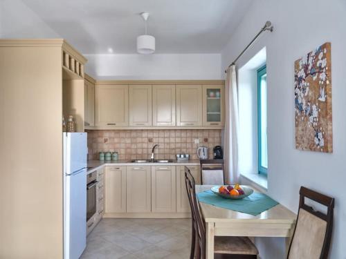 a kitchen with a table with a bowl of fruit on it at Two Bedroom Cycladic House With Sea View in Kampos Paros