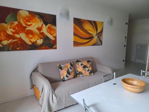 a living room with a couch and two paintings on the wall at appartamenti ACTIVESTAY in Arco