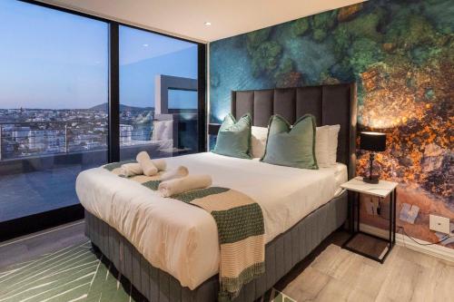 Un dormitorio con una cama grande con una ventana grande. en Penthouse with a view to die for!, en Ciudad del Cabo