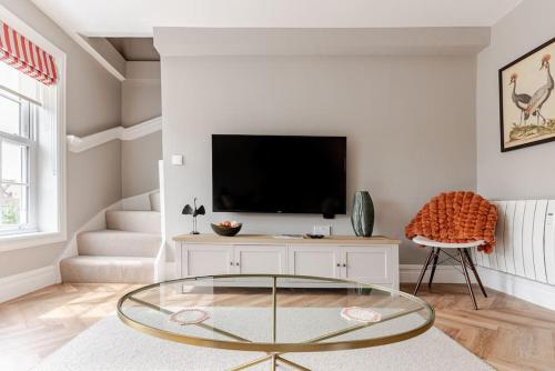 a living room with a tv and a glass table at Stunning new Duplex apartment - Christchurch in Christchurch