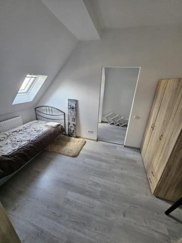an attic bedroom with a bed and a closet at Apartments Angels o k b in Altenburg