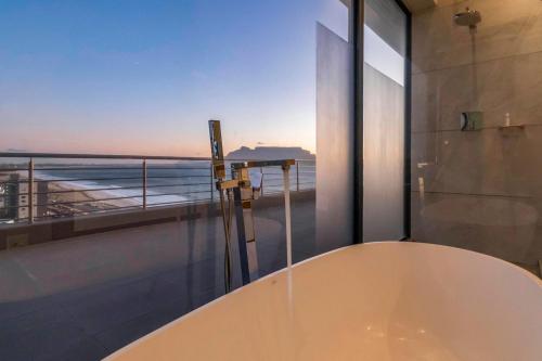 y baño con bañera y vistas al océano. en Penthouse with a view to die for!, en Ciudad del Cabo