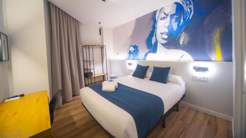 a bedroom with a bed with a large painting on the wall at Hotel Sleep Turia music & art in Lliria