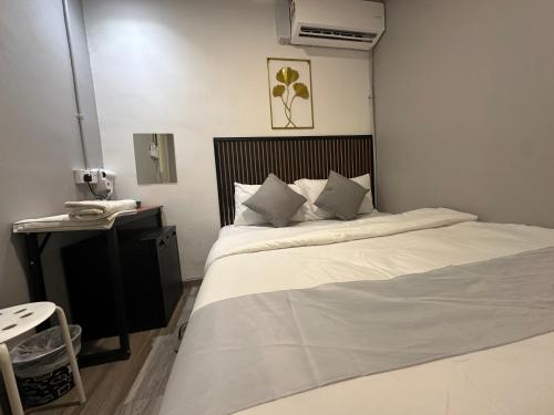 a bedroom with a large white bed and a desk at SS Grey House in Kuala Lumpur
