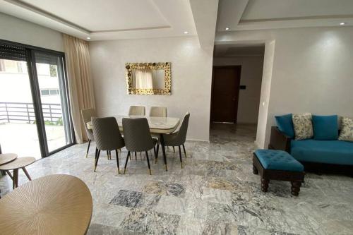 a living room with a table and a blue couch at Appartement neuf luxe OLM à Rabat in Rabat