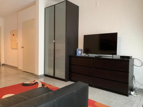 a living room with a television and a black dresser at Discovery Apartment Estrela in Lisbon