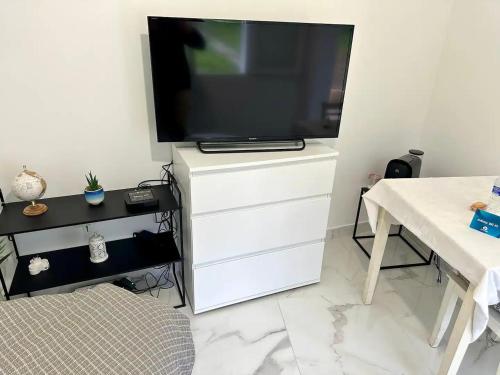 a white dresser with a television on top of it at Appartement 1 - Orsay, France in Orsay