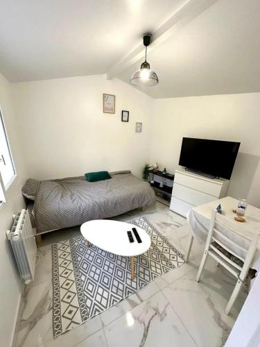 un salon avec un lit et une table dans l'établissement Appartement 1 - Orsay, France, à Orsay
