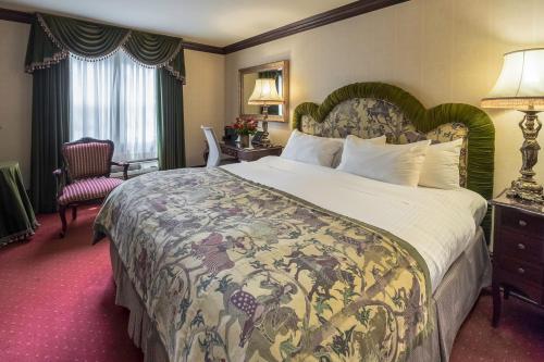 a hotel room with a large bed and a chair at Prince of Wales in Niagara on the Lake