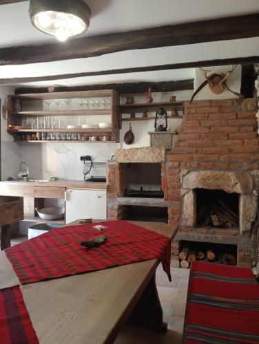 a kitchen with a brick oven with a red blanket at Мехса in Svetoslav