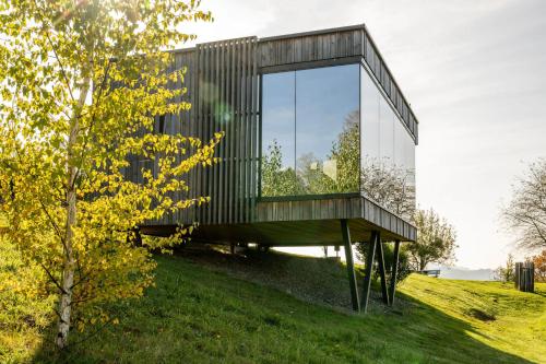 a glass house on top of a grassy hill at WURZENBERG Hotel Lodges Südsteiermark in Gamlitz