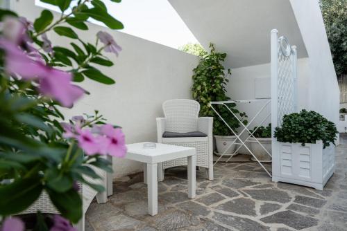 a patio with a chair and a table and flowers at Eunymos Panarea in Panarea