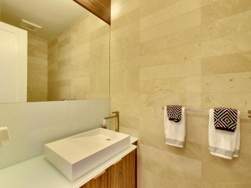 a bathroom with a white sink and a mirror at View CN Tower and Lake from the Sky! in Toronto
