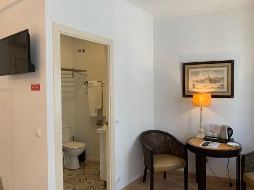 a room with a table and a chair and a toilet at Discovery Apartment Estrela in Lisbon