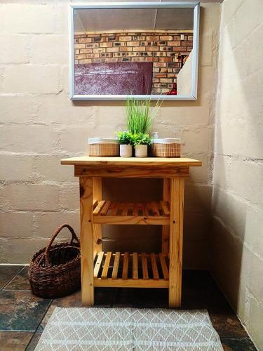 a wooden table with plants on it next to a wall at 2K City Studios Not Self catering in Graskop