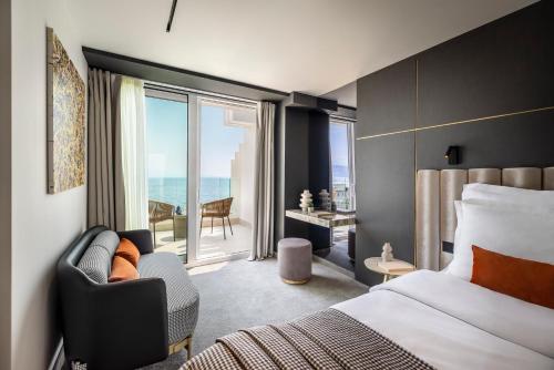 a hotel room with a bed and a chair and a window at Grand Hotel Adriatic in Opatija
