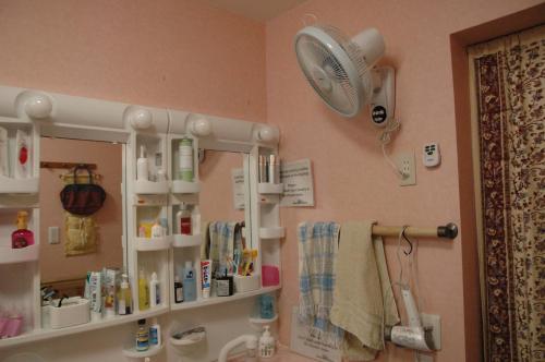 a bathroom with a sink with a mirror and a fan at Oyama Guesthouse Kyoto in Kyoto