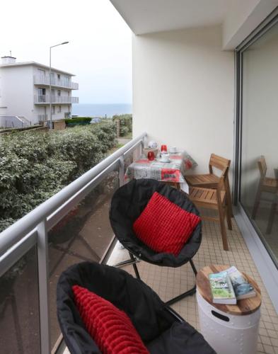un balcon avec une table et des chaises et l'océan dans l'établissement Studio résidence les gémeaux, à Quiberon