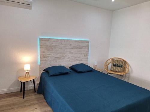 a bedroom with a blue bed and a chair at Chez Marine ô Marines in Saint-François