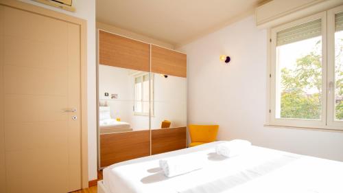 a bedroom with a white bed and a mirror at Sardinianworld - Otton House in Oristano