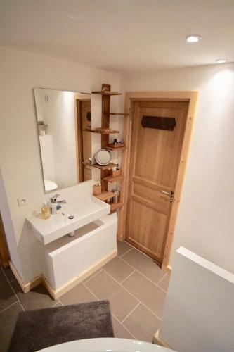 une salle de bain avec un lavabo blanc et un miroir dans l'établissement Chalet 4 étoiles La Saulire, à Villard-Reculas