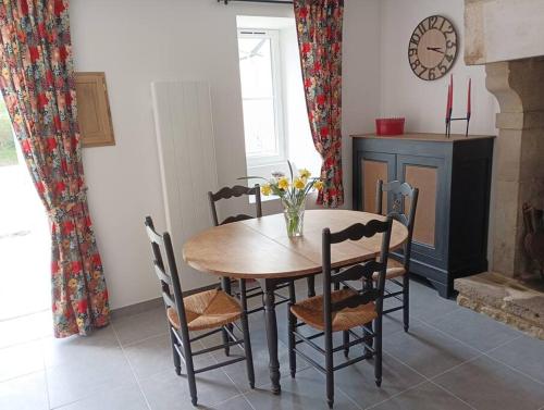 une salle à manger avec une table et des chaises et une cheminée dans l'établissement Gîte Les Pages, à Yvetot Bocage