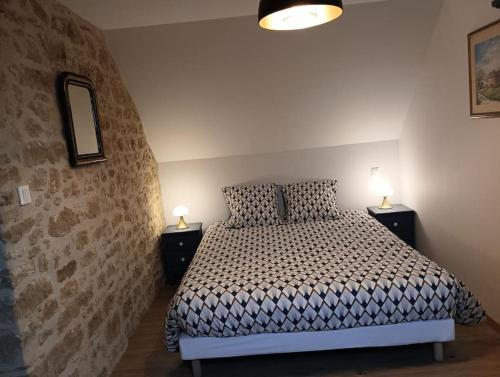 une chambre avec un lit et deux tables de nuit avec lampes dans l'établissement Gîte Les Pages, à Yvetot Bocage