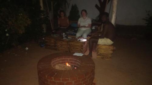 a group of people sitting around a fire pit at Moshi hostel lodge in Msaranga