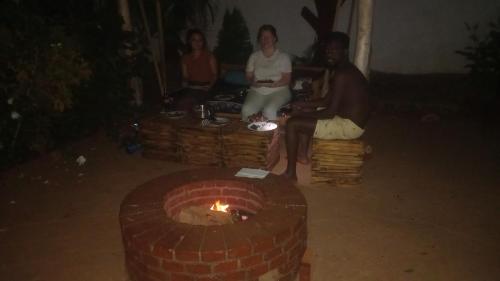 a group of people sitting around a brick fireplace at Moshi hostel lodge in Msaranga
