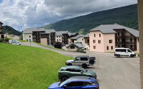 un groupe de voitures garées sur un parking dans l'établissement Le Chamois, à Lélex