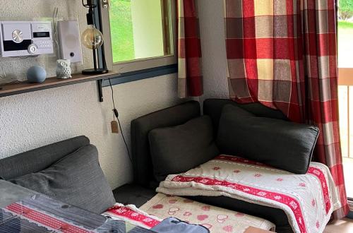 un salon avec un canapé et une fenêtre dans l'établissement Le Chamois, à Lélex