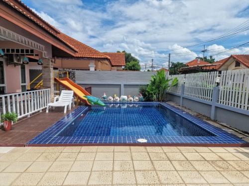 a swimming pool with a slide in a backyard at Bluepool Villa Pattaya in Bang Sare