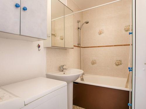 une salle de bain blanche avec un lavabo et une baignoire dans l'établissement Appartement 2 chambres avec balcons et parking à Cabourg - FR-1-788-36, à Cabourg