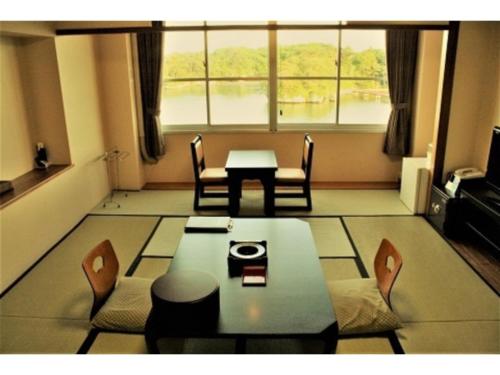 a living room with a table and chairs and a large window at Hotel Zekkei no Yakata - Vacation STAY 47614v in Takagi