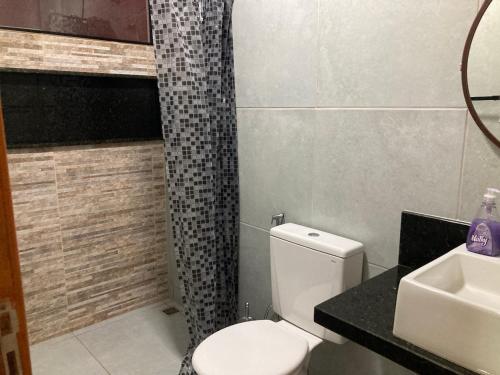 a bathroom with a toilet and a sink at Seu conforto em Gravatá-PE, com piscina aquecida in Gravatá