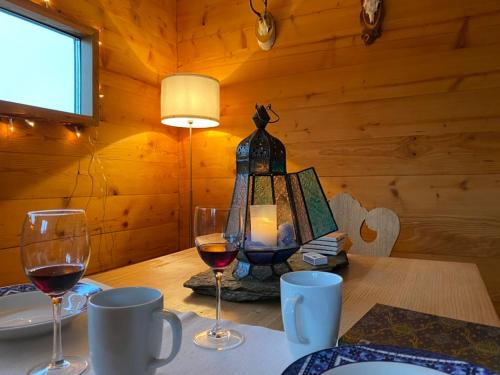 a table with two glasses of wine and a lamp at Chalet Safran in Grächen