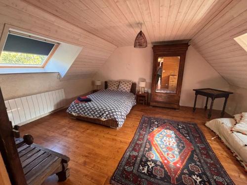 Cette chambre mansardée comprend deux lits et un banc. dans l'établissement Maison dans la campagne bretonne, à Glomel