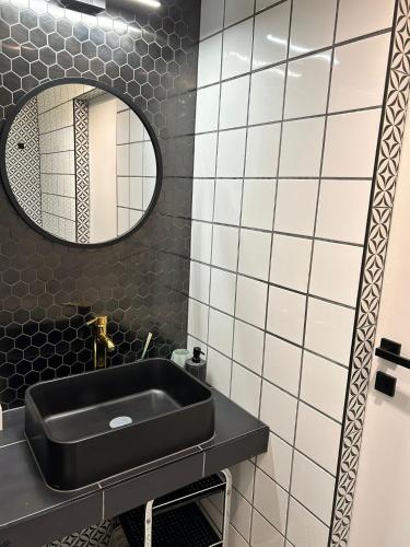 a bathroom with a black sink and a mirror at Poziom -1 in Sandomierz