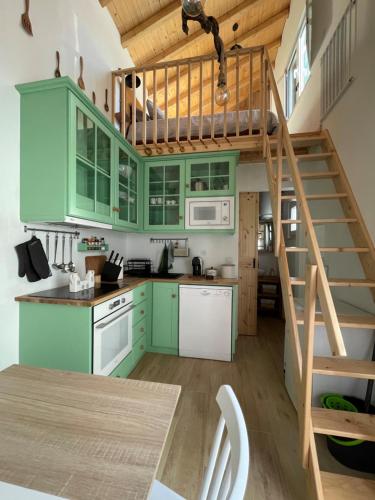 a kitchen with green cabinets and a spiral staircase at Casa Valada My Land in Valada