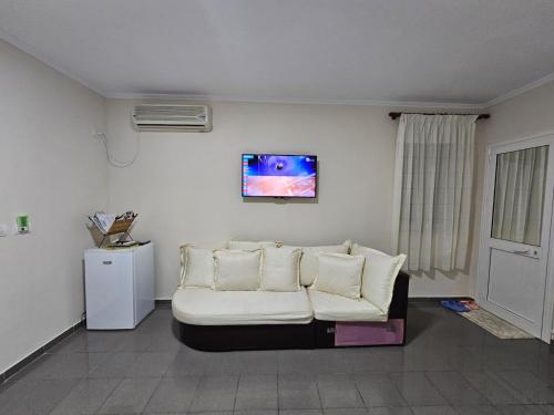 Endi City Centre Room في تيرانا: غرفة معيشة بها أريكة ولوحة معلقة على الحائط