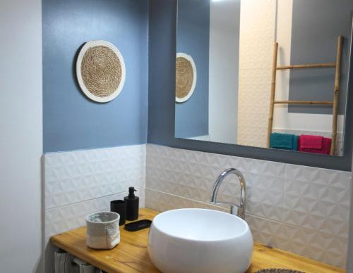 une salle de bain avec un lavabo blanc et un miroir dans l'établissement Appartement climatisé avec terrasse parking piscine et terrains de tennis, au Cap d'Agde