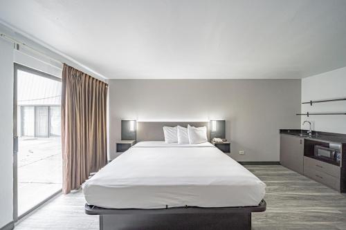 a bedroom with a large bed and a large window at Studio 6 Pocatello, ID in Pocatello